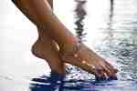 Female feet above the water with bracelet on ankle ©  monstersparrow -Fotolia.com